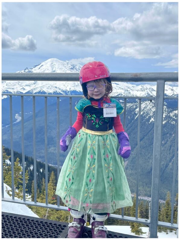 Bus ride and transportation from seattle and bellevue to snoqualmie pass, summit at snoqualmie, alpental, summit west, summit central. Photo of young girl with dress and skis in front of Mt. Rainier.